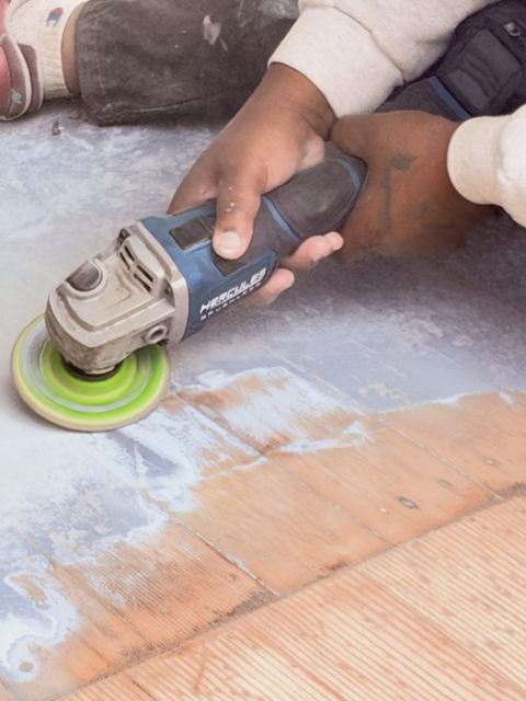 Grinder removing old paint from a porch floor
